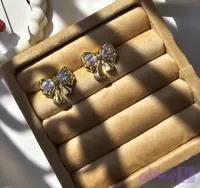 گوشواره پاپیون جواهری طلایی با رنگی گرم و ثابت و جواهراتی درخشان ضد حساسیت و زیبا از آویدخت