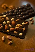 بار آجیلی ماین حاوی شکلات تلخ بلژیکی ۷۰٪ و انواع مغزهای خام