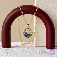 گردنبند زنانه با آویز دایره‌ای طرح دم وال طلایی و نگین‌های آبی با زنجیر پولکی