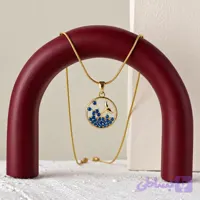 گردنبند زنانه با آویز دایره‌ای طرح دم وال طلایی و نگین‌های آبی با زنجیر ماری لوله‌ای